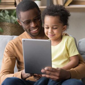 Father and child looking at a tablet smiling