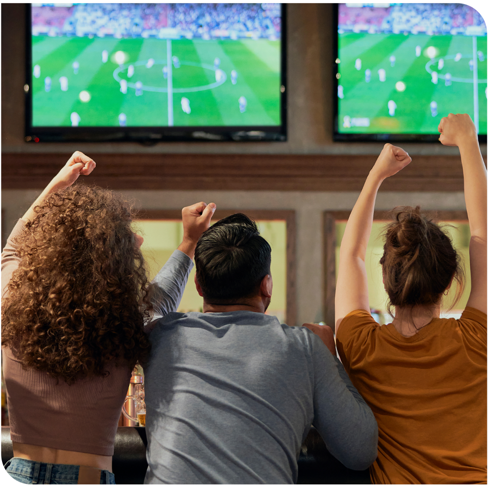 Bar scene with multiples TVs showing the same game and people cheering